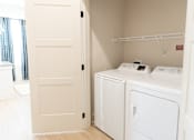 Thumbnail 4 of 53 - Two machines in opened door laundry at District on the Etowah Apartments, Canton Georgia