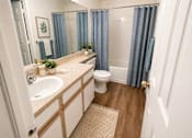 Thumbnail 17 of 40 - A bathroom with a toilet, sink, and shower.