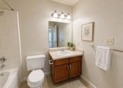Thumbnail 25 of 40 - A white toilet sits next to a sink in a bathroom.