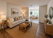 Thumbnail 6 of 40 - A living room with a white couch, a coffee table, and a painting on the wall.