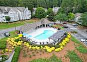 Thumbnail 2 of 40 - A pool surrounded by yellow flowers and green grass.