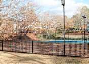 Thumbnail 30 of 40 - a tennis court with a fence in front of a pool at The Crest at Berkeley Lake, Duluth