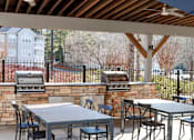 Thumbnail 27 of 40 - The Crest at Berkeley Lake grilling station with tables and seating located in Duluth, GA 30096