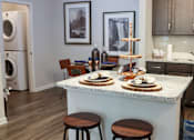 Thumbnail 7 of 27 - a kitchen with a counter with plates on it and a washing machine at The Crest at Laurel Canyon Apartments, Canton, GA