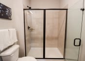 Thumbnail 20 of 60 - a small bathroom with a shower and a toilet at The Crest at South Point Apartments, McDonough, GA