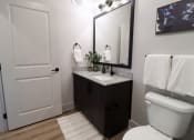 Thumbnail 19 of 60 - a bathroom with a toilet and a sink and a mirror at The Crest at South Point Apartments, McDonough, GA, 30253