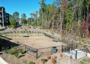Thumbnail 34 of 46 - the fenced in dog park with trees in the background at The Wren Apartments, Lawrenceville, GA