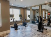 Thumbnail 32 of 46 - a gym with treadmills and weights in a home gym at The Wren Apartments, Lawrenceville, GA
