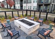 Thumbnail 20 of 46 - an outdoor patio with a fire pit and chairs at The Wren Apartments, Lawrenceville, Georgia