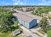 Thumbnail 5 of 13 - A blue building is in the foreground of a street with cars and other buildings in the background.