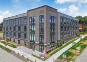 Thumbnail 3 of 18 - a large brick building with many windows and a sidewalk