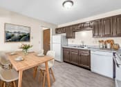 Thumbnail 9 of 13 - A kitchen with brown cabinets and a wooden table with chairs.