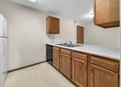 Thumbnail 8 of 11 - A kitchen with wooden cabinets and a white fridge.