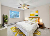 Thumbnail 7 of 11 - A bedroom with a bed, a ceiling fan, and a window.