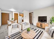 Thumbnail 9 of 11 - A living room with a white couch, a wooden coffee table, and a television.