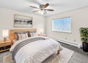Thumbnail 11 of 11 - A bedroom with a large bed, a ceiling fan, and a window with blinds.