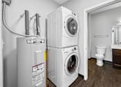 Thumbnail 5 of 11 - A small laundry room with a washer and dryer stacked on top of each other.