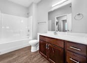 Thumbnail 6 of 11 - A white bathroom with a toilet, sink, and shower.