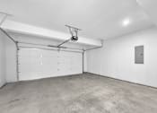 Thumbnail 12 of 12 - A garage with a white door and a grey floor.