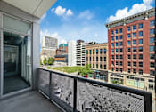 Thumbnail 8 of 8 - A balcony with a mesh screen overlooking a cityscape.