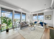 Thumbnail 6 of 18 - a living room with large windows and a rug