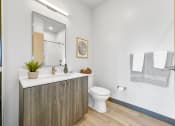 Thumbnail 16 of 18 - a bathroom with a toilet and a sink and a mirror