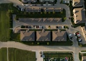 Thumbnail 2 of 18 - A bird's eye view of a residential area with houses and cars.