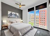Thumbnail 7 of 8 - A bedroom with a large bed and a ceiling fan.