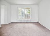 Thumbnail 12 of 14 - an empty living room with a large window and carpet
