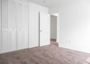 Thumbnail 13 of 14 - an empty bedroom with white closet doors and carpet