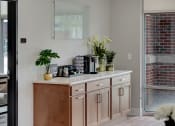 Thumbnail 2 of 48 - a kitchen with wooden cabinets and a counter with vases and flowers