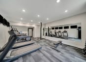 Thumbnail 8 of 48 - a gym with cardio equipment and mirrors on the wall