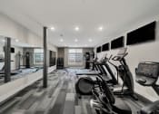 Thumbnail 7 of 48 - a gym with cardio machines and televisions on the wall