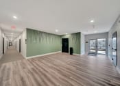 Thumbnail 10 of 48 - a long hallway with green walls and wooden floors and a glass door