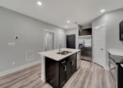 Thumbnail 18 of 48 - a kitchen with a large island and a stainless steel refrigerator