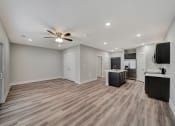 Thumbnail 20 of 48 - an empty living room with a ceiling fan and a kitchen
