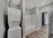 Thumbnail 29 of 48 - a white washer and dryer in a room with a shower and a bathroom