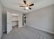 Thumbnail 23 of 48 - an empty living room with a ceiling fan and a door to a kitchen