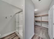 Thumbnail 30 of 48 - a walk in closet with a mirrored closet door and a shower