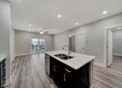 Thumbnail 19 of 48 - an open living room and kitchen with a sink and a ceiling fan