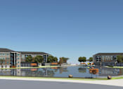 Thumbnail 32 of 32 - A large building complex with a pond in the middle.