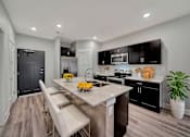 Thumbnail 13 of 48 - A modern kitchen with a dining table and chairs.