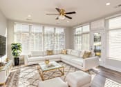 Thumbnail 47 of 48 - A white living room with a glass coffee table and a white sofa.