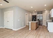 Thumbnail 16 of 32 - A kitchen with white cabinets and a wooden island.