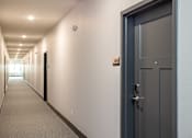 Thumbnail 14 of 32 - A long hallway with a door on the right.