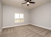 Thumbnail 3 of 32 - A room with a ceiling fan and a window overlooking a desert landscape.