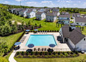 Thumbnail 2 of 44 - A swimming pool surrounded by a grassy area and a fence.