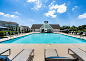 Thumbnail 43 of 44 - A swimming pool with lounge chairs and a building in the background.
