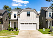 Thumbnail 36 of 44 - A white garage door is in the center of a driveway.
