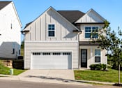 Thumbnail 6 of 44 - A two-story house with a white garage door.